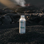 Bottle of Detox face mask on a volcanic surface with steam in the background
